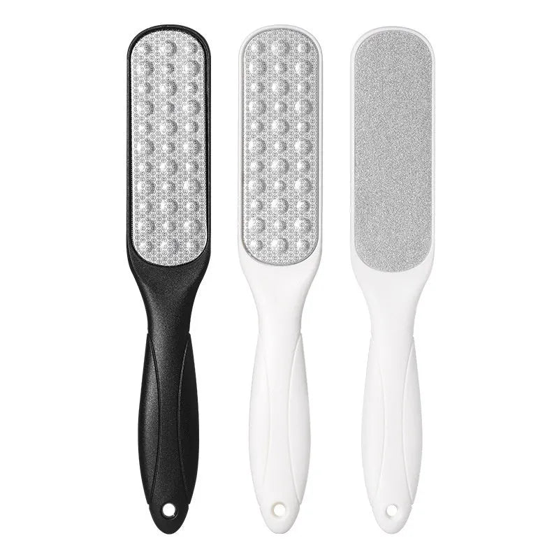 Stainless steel foot grinder tool with white and black double-sided sandpaper files for callus removal.