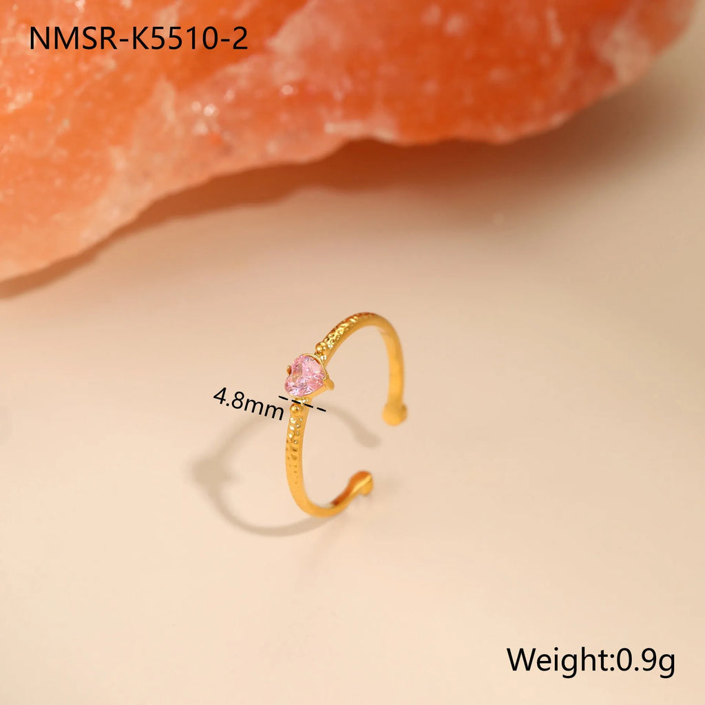 Open ended stainless steel ring with a geometric heart shape and inlaid zircon stone in white, pink, or green.