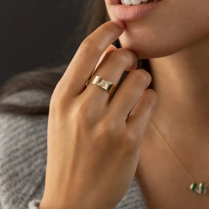 Gold electroplated women's ring with zircon stone on finger, showing copper construction and size options 6-10
