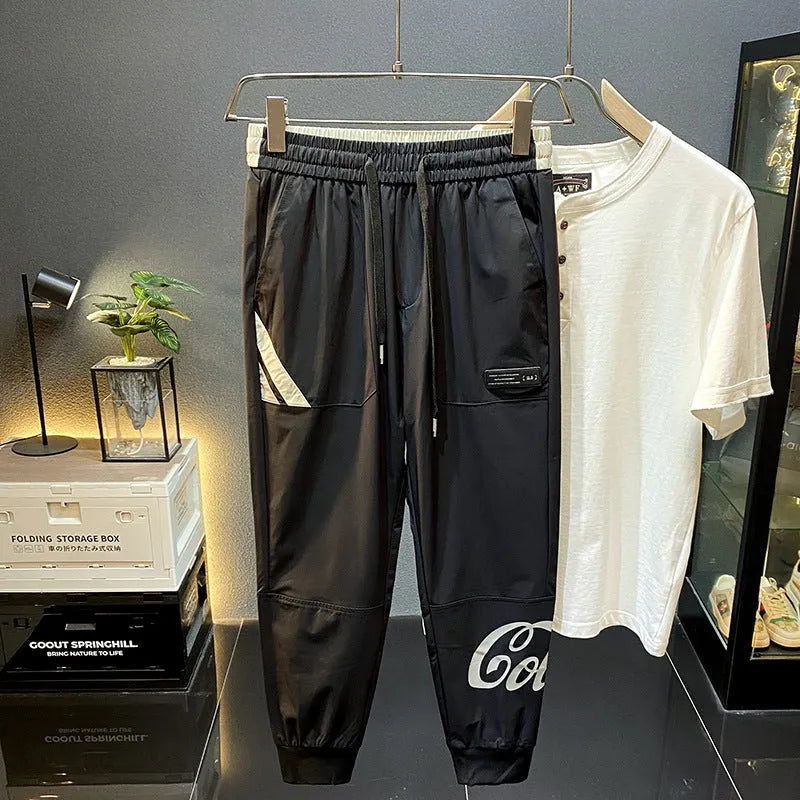 Man wearing black cropped cotton trousers with an ankle banded cuff.