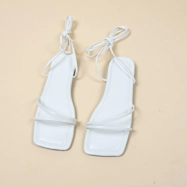 Women's flat sandals with ankle ring bandage cloth detail in white, black and orange.