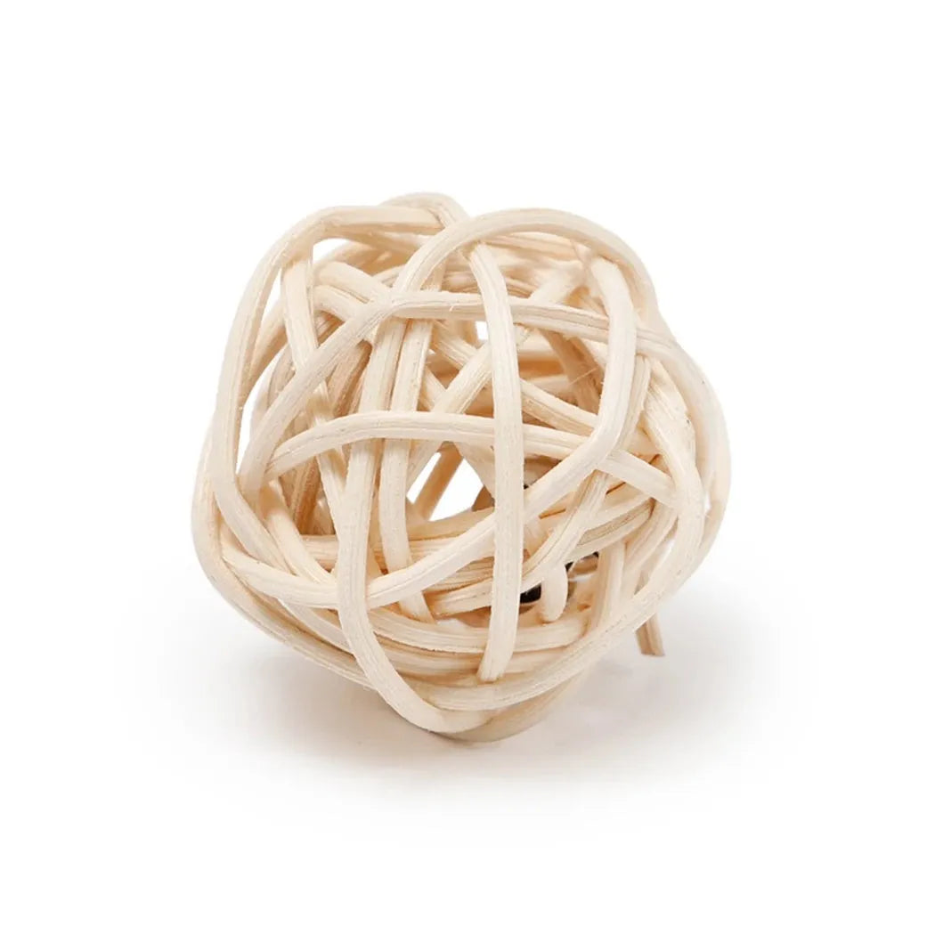 Two cat toys: a natural rattan ball with a bell and a colourful faux feather ball on a plain surface.