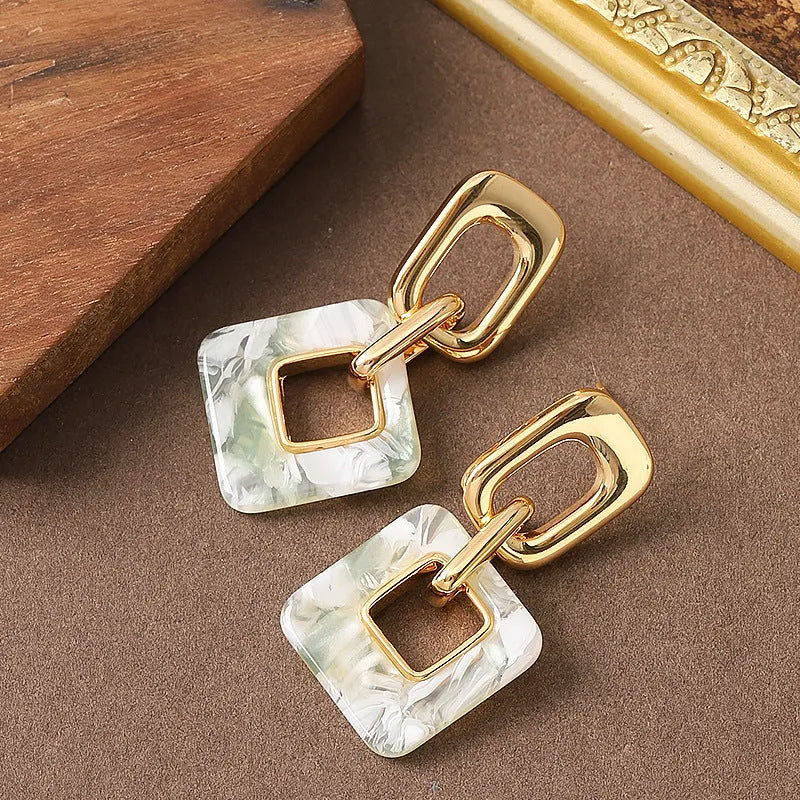 Hollow geometric square earrings with chamfered corners in metallic finish