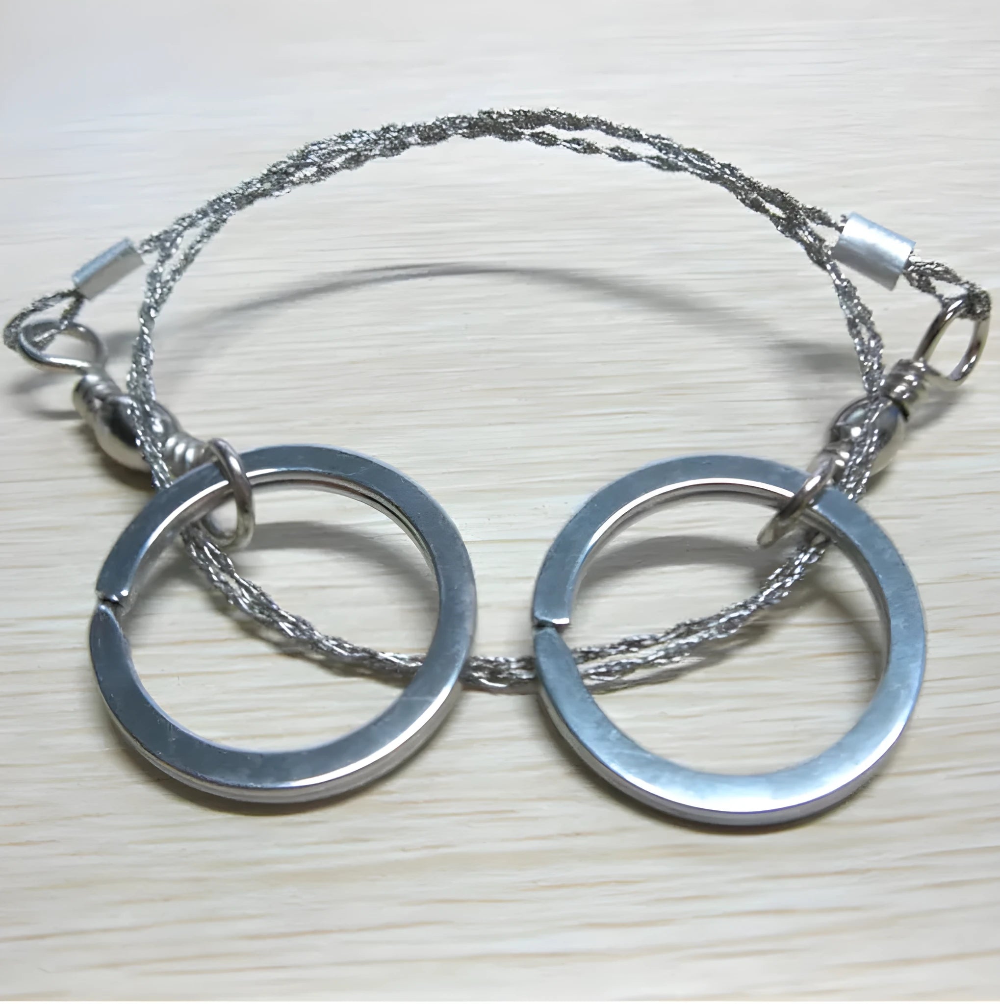 Survival wire saw with stainless steel blade and finger loops, showing 55cm length and pull ring