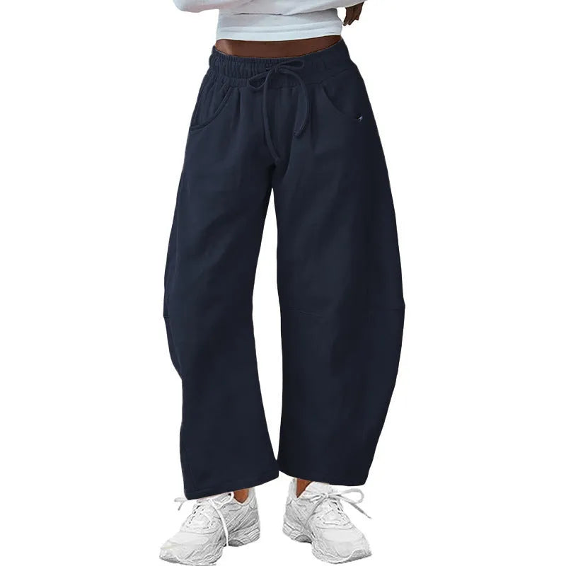 Women's loose grey cropped sweatpants with drawstring waist and side pockets on a hanger.