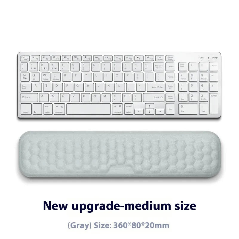 Customisable memory foam mouse wrist pad with black cloth cover on a desk.