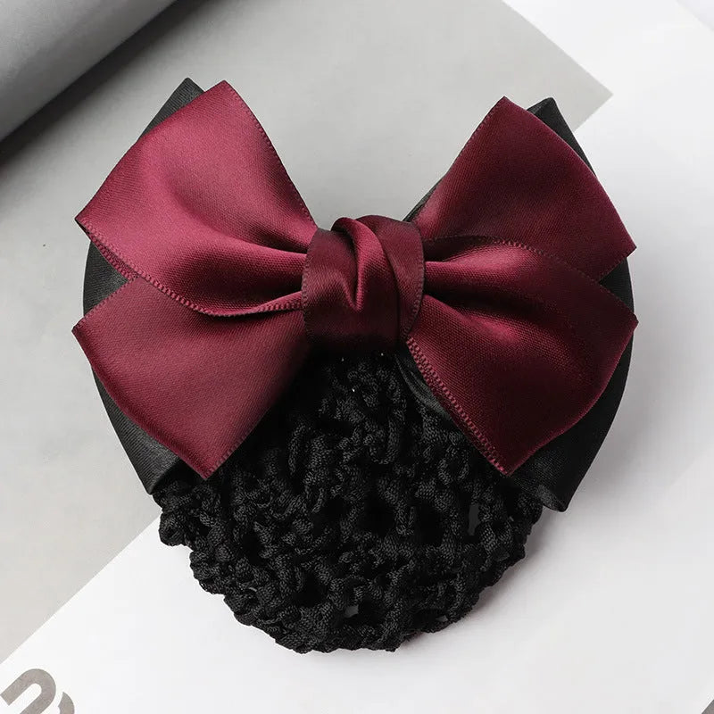 Professional hair clip with a black net pocket and a red flower bow ornament on a white background.
