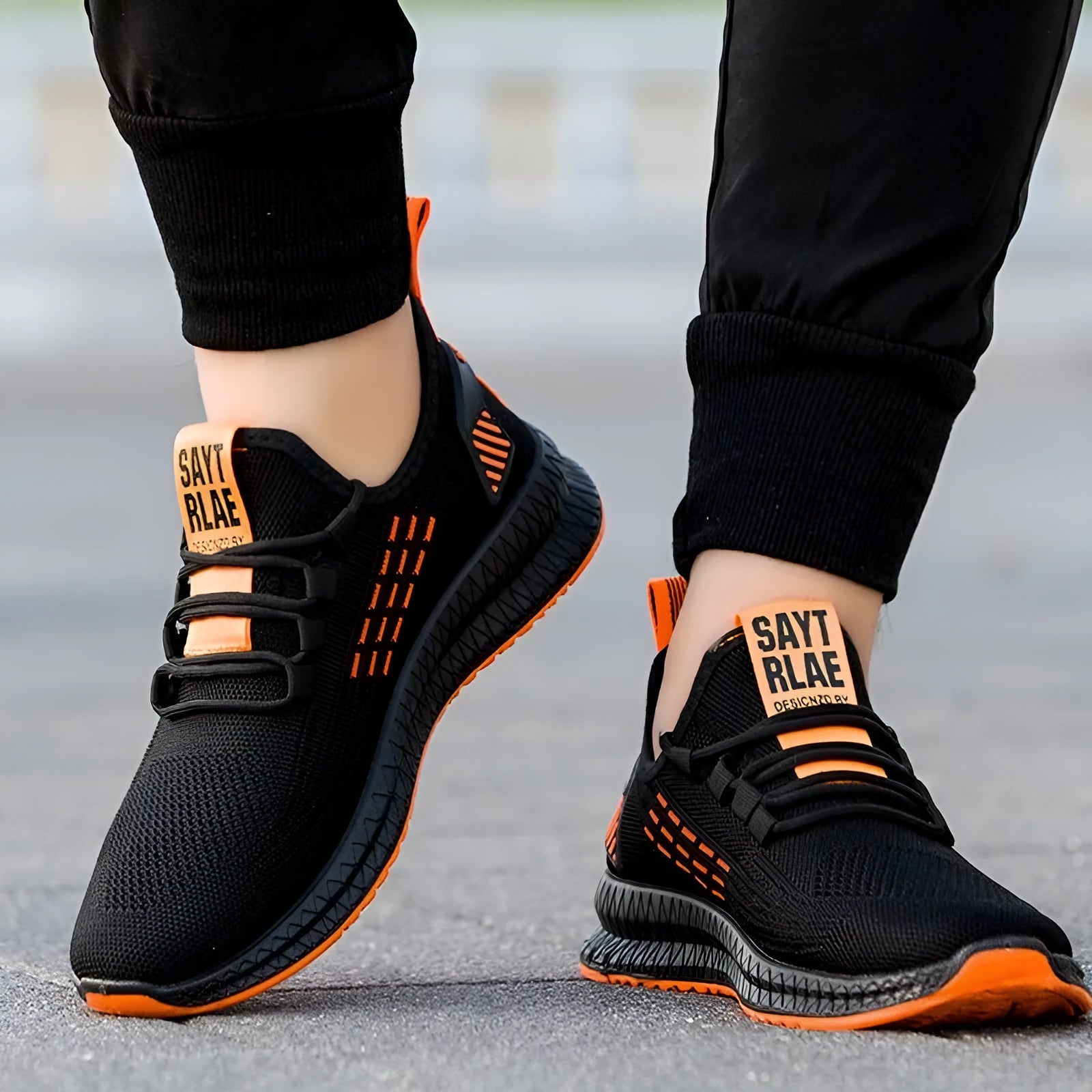 Men's black sports shoes with flying three bars pattern and cross strap detail on low-top design