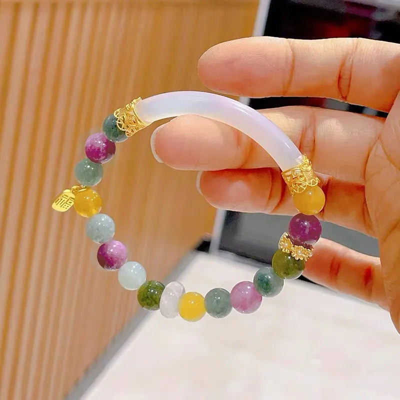 Rainbow coloured electroplated tourmaline half bracelet for women on a wrist.