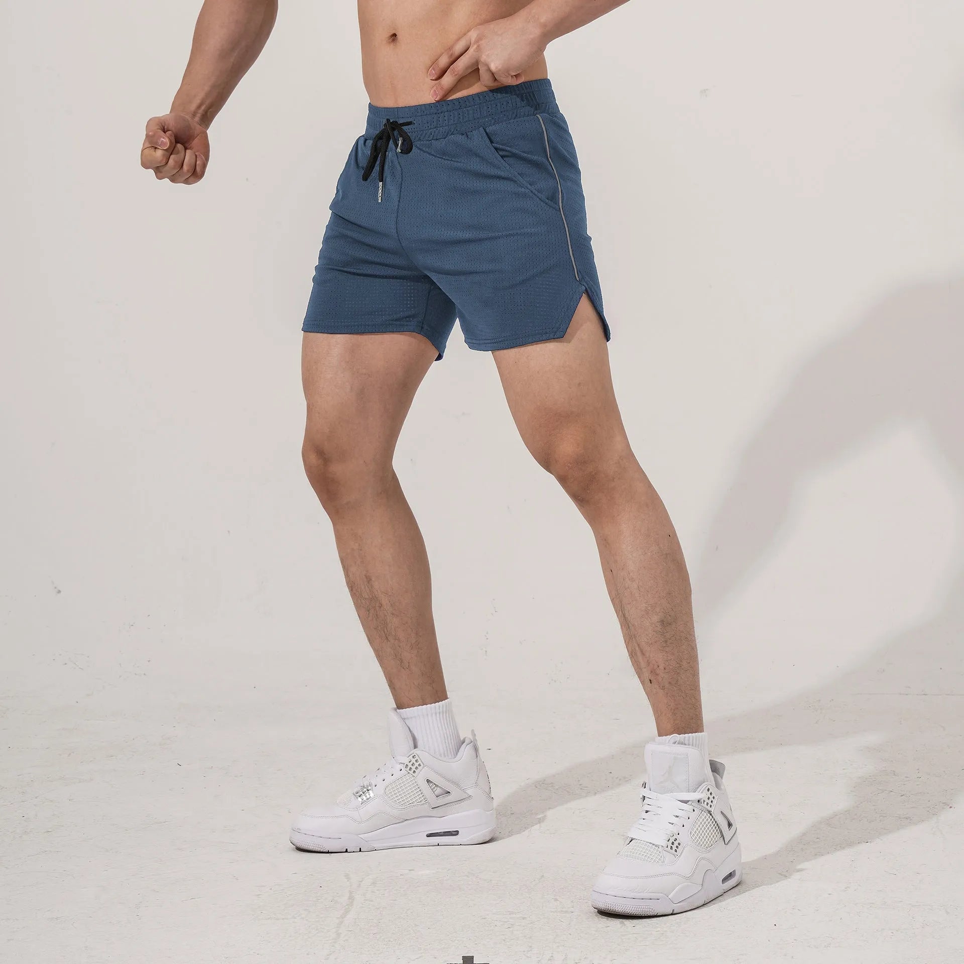 Men's black polyester straight-leg fitness shorts laid flat, showing sports style.
