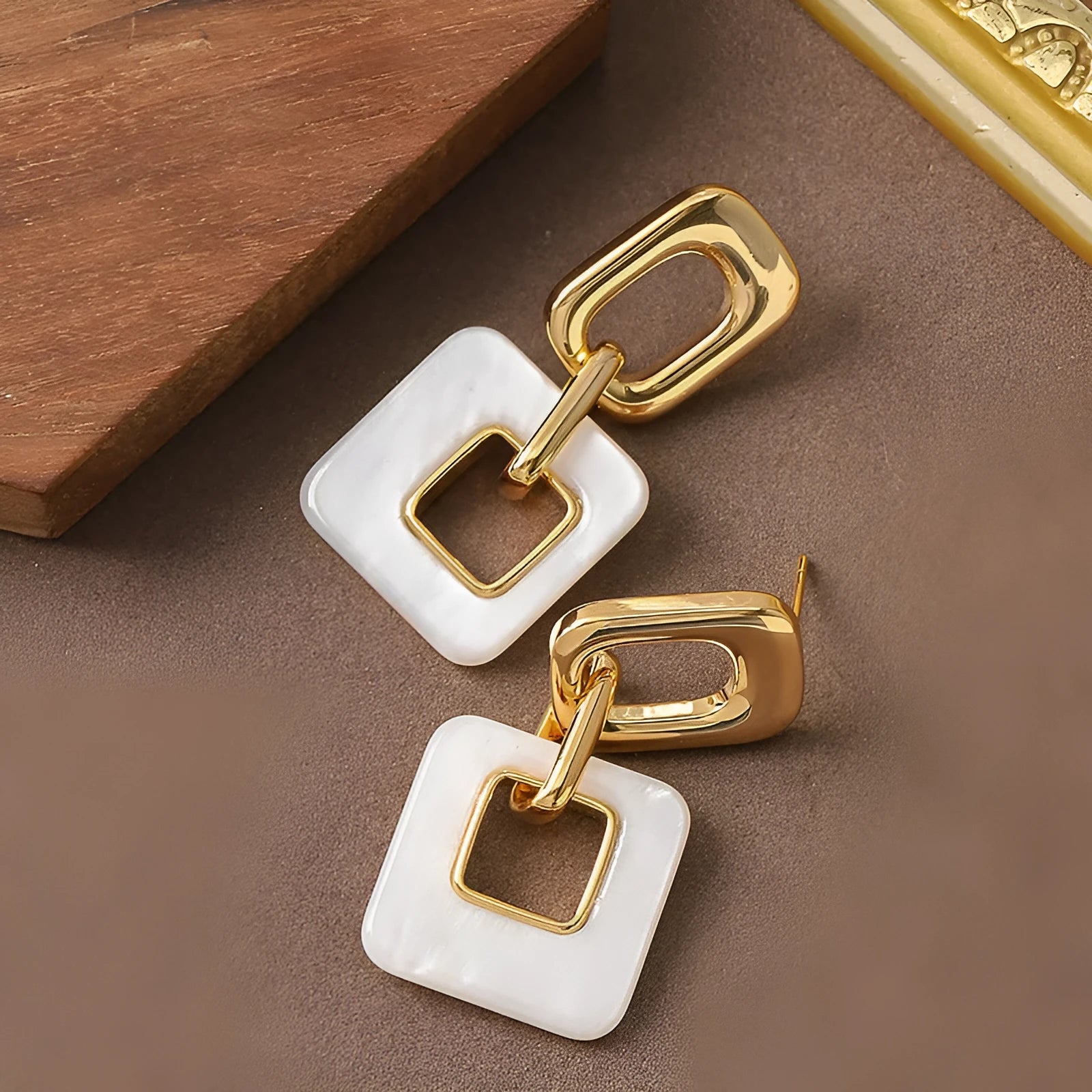 Hollow geometric square earrings with chamfered corners in metallic finish