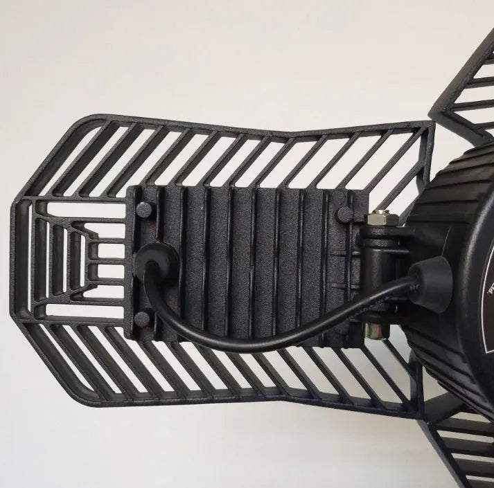 A foldable industrial LED garage flood light with a die-cast aluminum body, shown in a workshop setting.