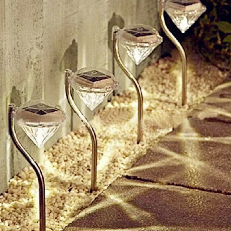 White solar-powered garden spotlight with adjustable head and solar panel on a stake for outdoor installation.