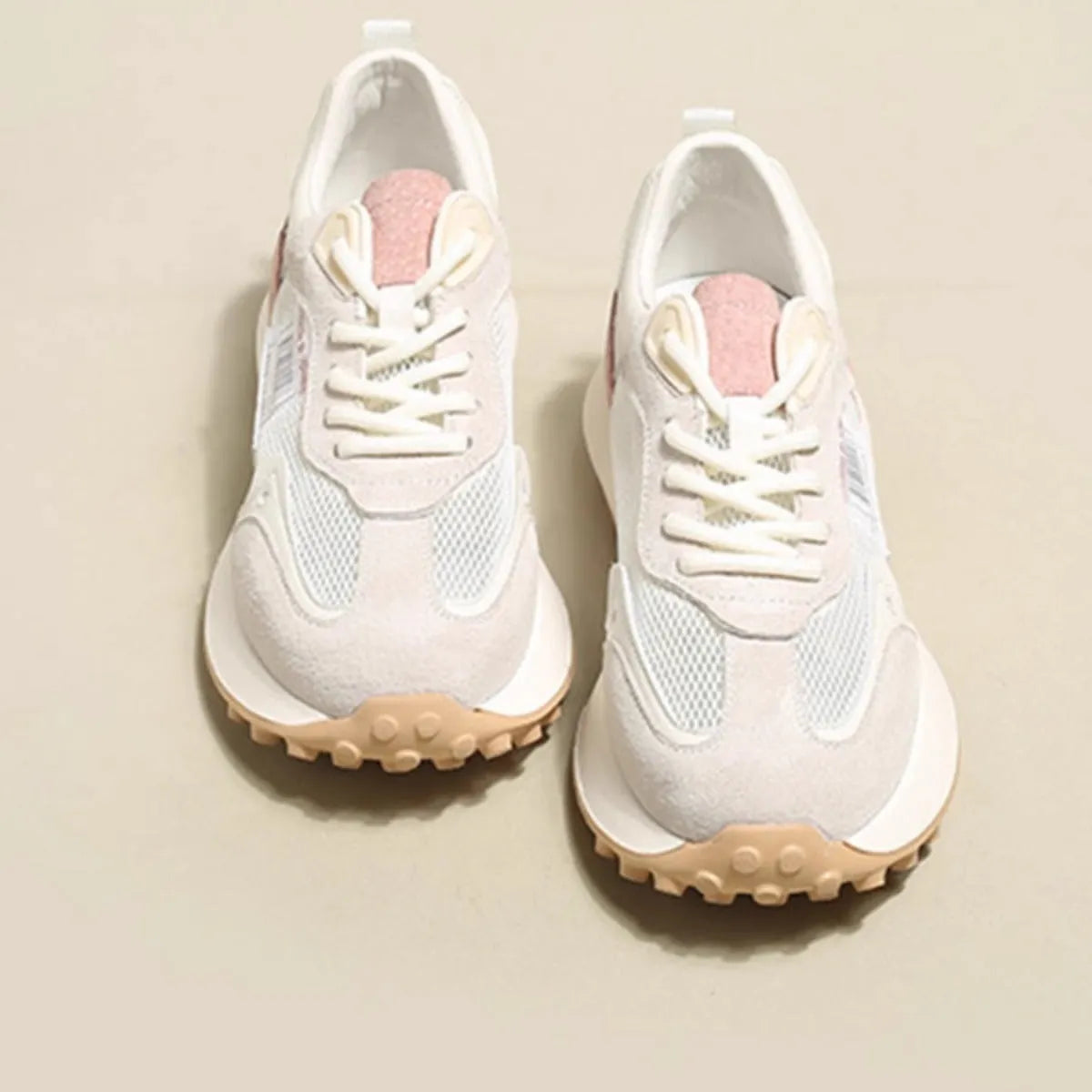 Grey and pink women's low-top retro sneakers with round toe and shallow mouth on a rubber sole.