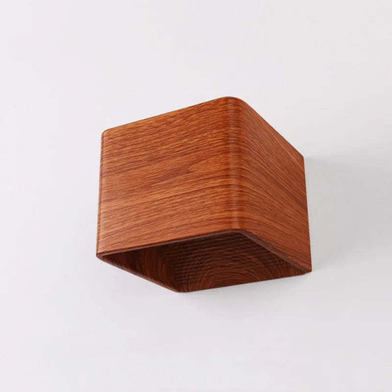 Square LED indoor wall lamp in black die-cast aluminium with warm white light on a wall