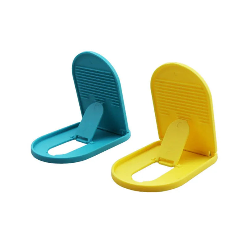 Plastic lazy bracket mobile phone stand in six colour options on a desk.