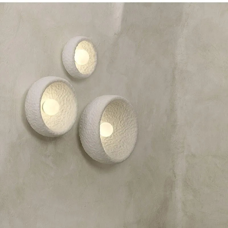 Japanese-style simple silent wall lamp with white resin shade on a wall.