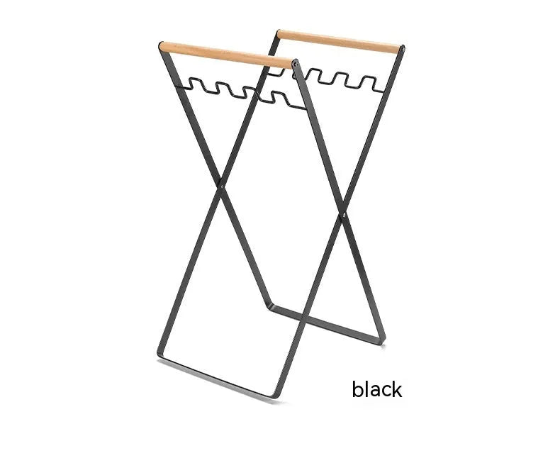 Black folding outdoor trash rack with a wooden handle, holding a rubbish sack.