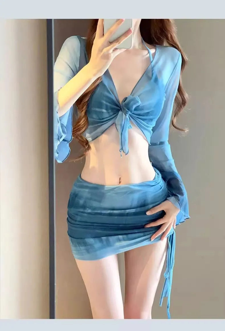 Women's blue high waist swimsuit four-piece set with shirt, bra, underwear, and skirt on beach