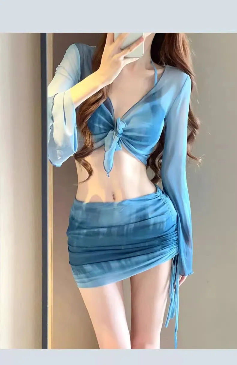 Women's blue high waist swimsuit four-piece set with shirt, bra, underwear, and skirt on beach