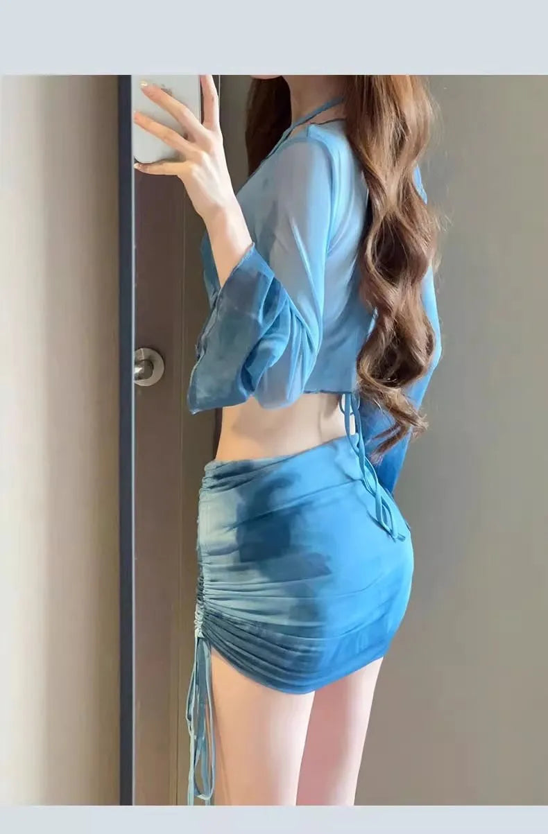 Women's blue high waist swimsuit four-piece set with shirt, bra, underwear, and skirt on beach