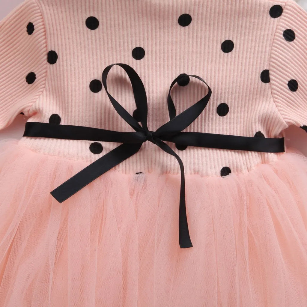 Baby girl wearing a long sleeve black lace tutu dress for a christening or birthday party.