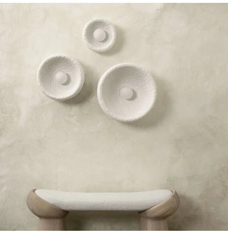 Japanese-style simple silent wall lamp with white resin shade on a wall.