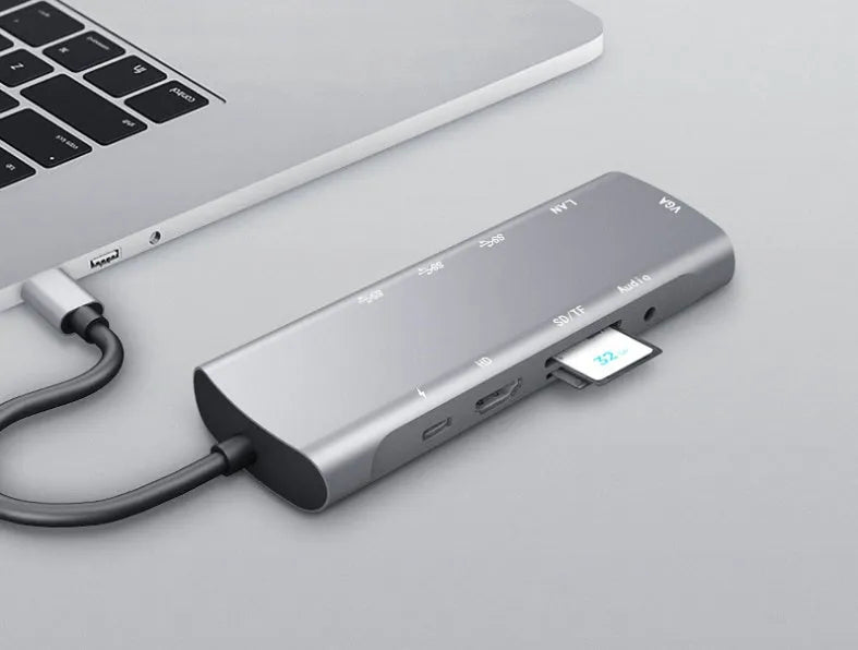 Grey aluminium USB-C docking station showing HDMI, VGA, USB 3.0, and power delivery ports