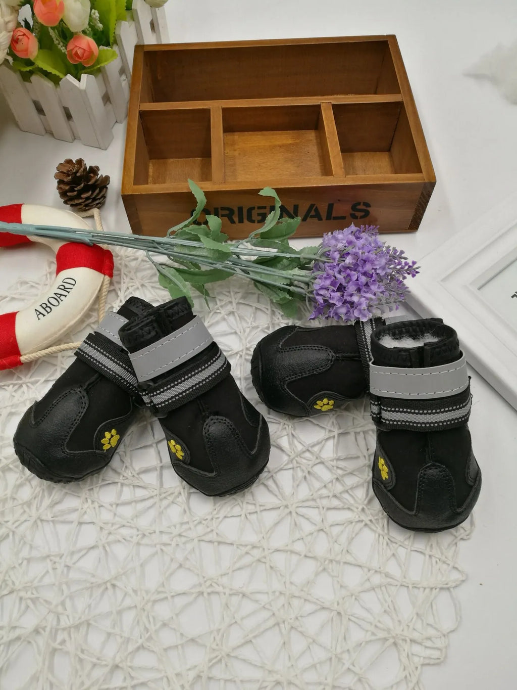 Black dog shoes with waterproof PVC sole and adjustable fuzzy belt on a dog's paw