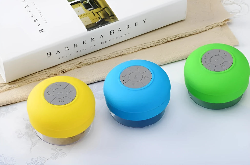Portable Bluetooth speaker with suction cup showing front speaker grille and side buttons
