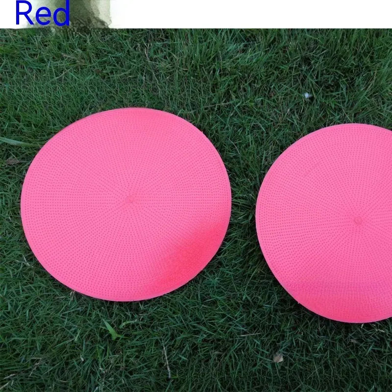 Yellow TPE football training target disc on grass, 23cm diameter flat landmark pad