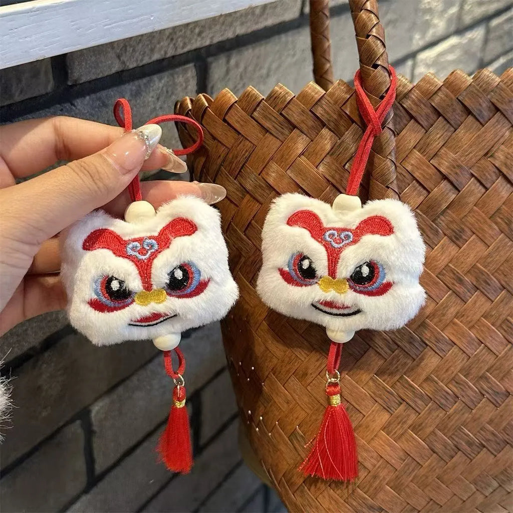 Blue and yellow handmade plush lion keychain ornaments with star stone decoration on white background.
