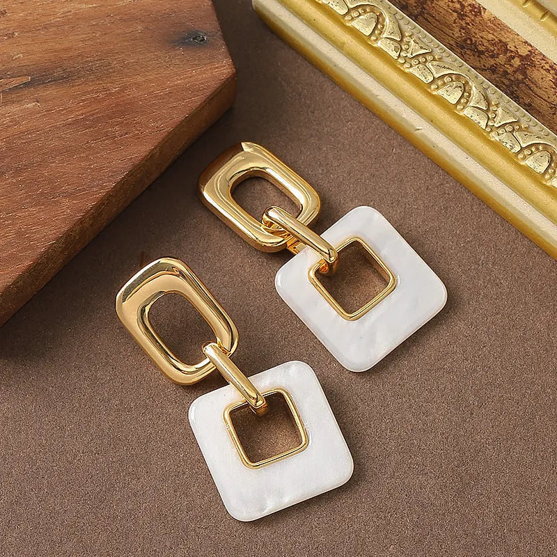 Hollow geometric square earrings with chamfered corners in metallic finish