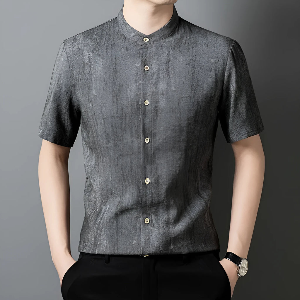 Man wearing a loose grey linen shirt with a stand collar and short sleeves, cardigan style.