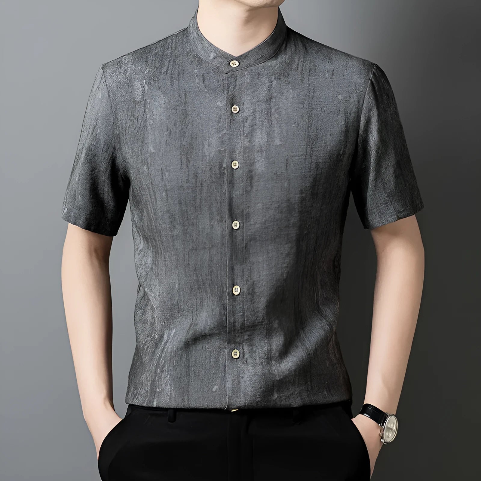 Man wearing a loose grey linen shirt with a stand collar and short sleeves, cardigan style.
