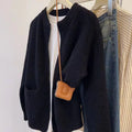 Beige viscose fibre soft wind cardigan coat with long sleeves on a hanger.
