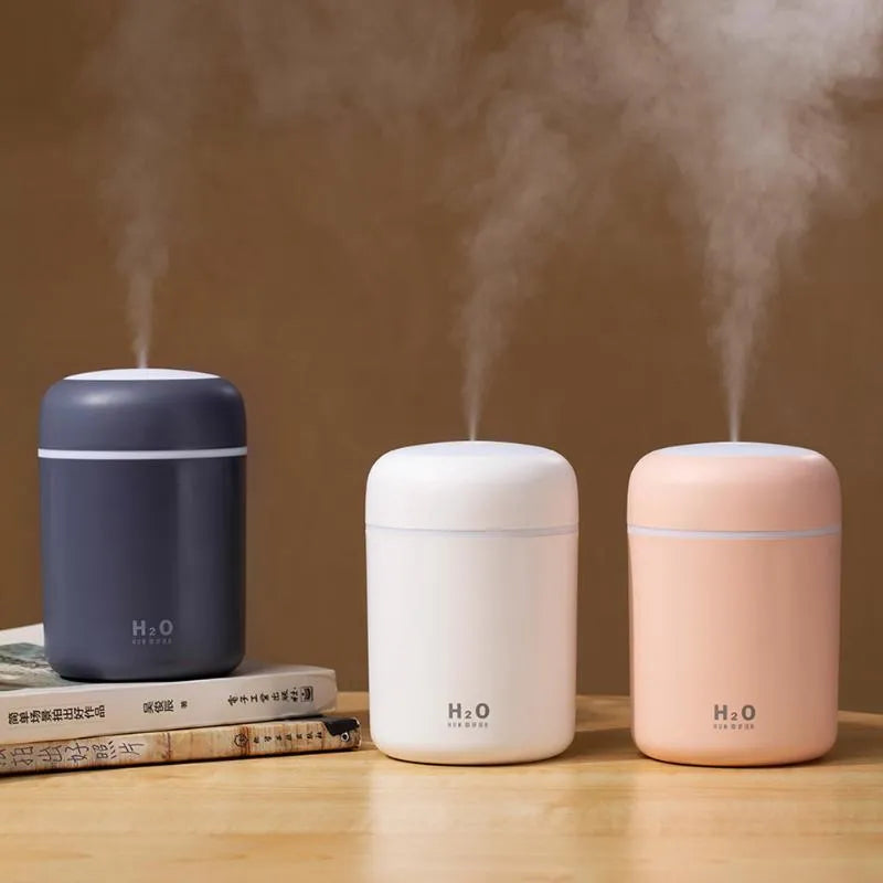 Pink USB portable humidifier with 300ml water tank on wooden desk surface