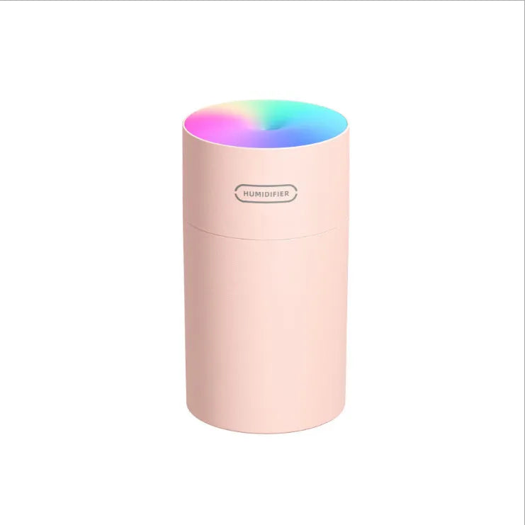 Pink USB portable humidifier with 300ml water tank on wooden desk surface