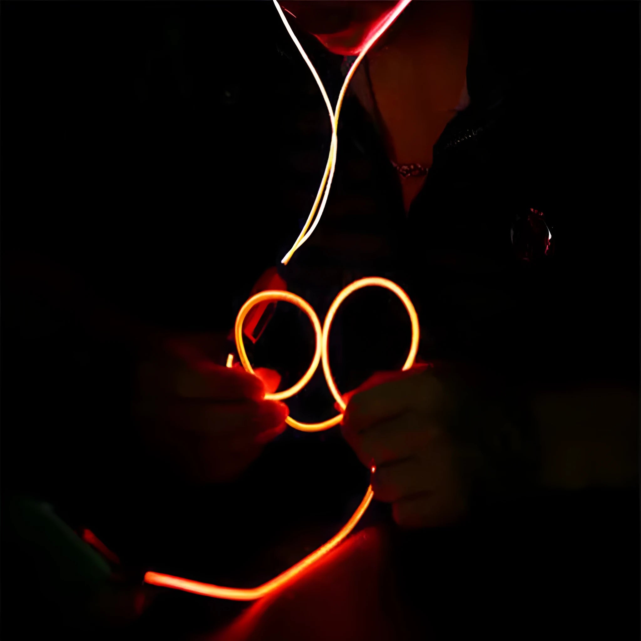 Blue wired earphones with glowing LED light lines on earpieces, showing 3.5mm plug and inline remote.