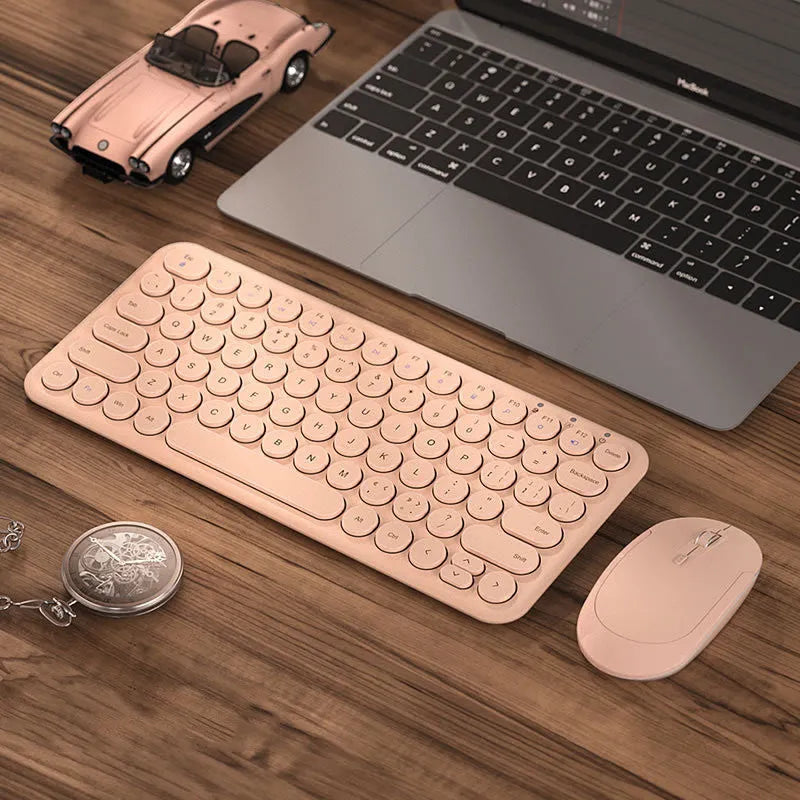 Ultra-thin white wireless keyboard and mouse set with USB receiver on a wooden desk.