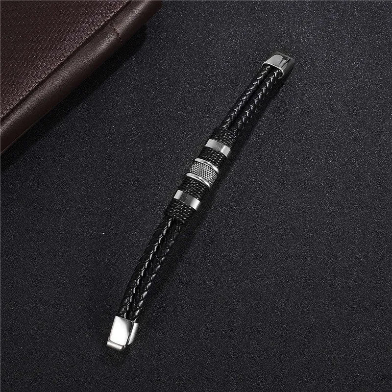 Black braid woven leather bracelet with titanium stainless steel accents for men on a neutral background