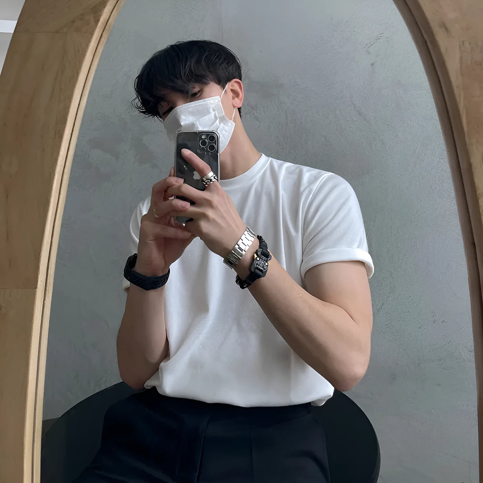 A man wearing a slim fit black cotton T-shirt with a round neck and half sleeves.