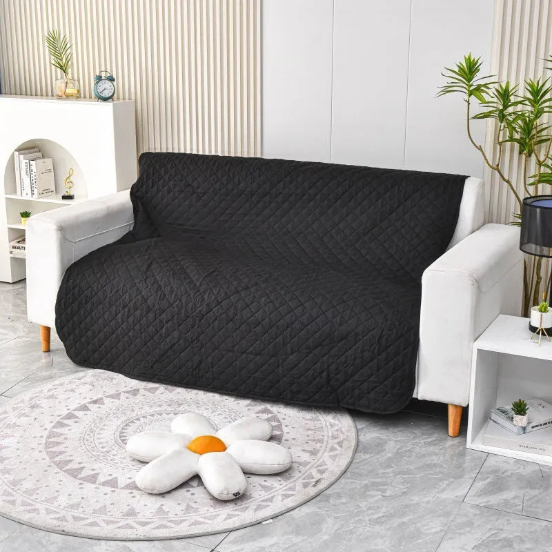 Reversible dog blanket showing two colours, laid flat on a sofa as a protective cover