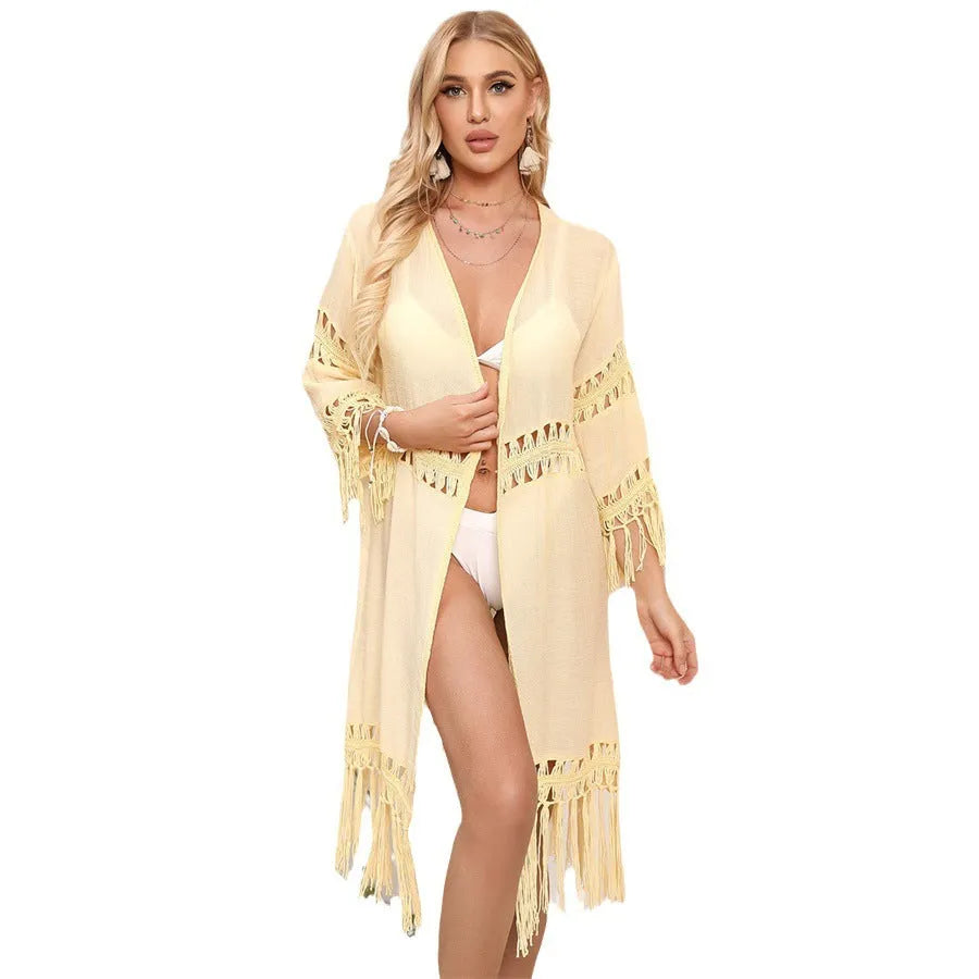 Yellow hand-crocheted acrylic cardigan with tassel details, laid flat as a women's beach cover-up.