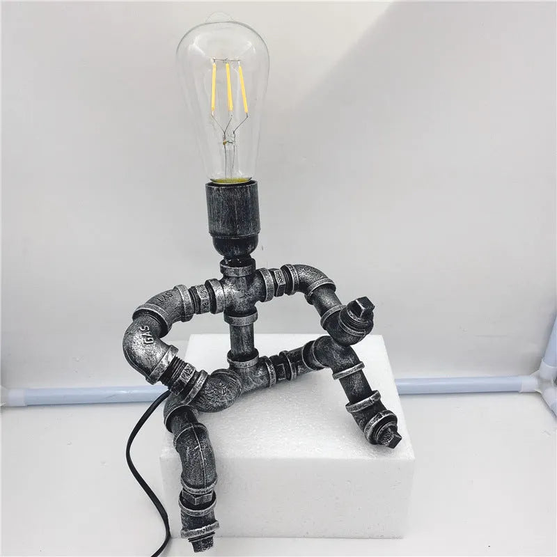 Industrial retro table lamp made from iron water pipes in vintage colour on a wooden desk