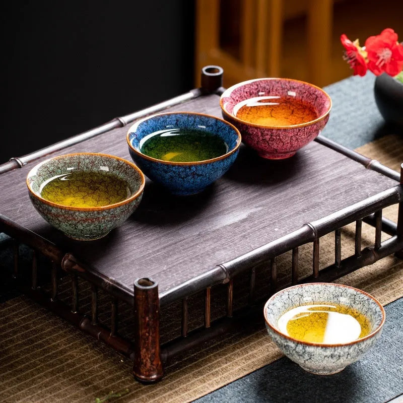 Set of four ceramic tea cups in light colour finish on table