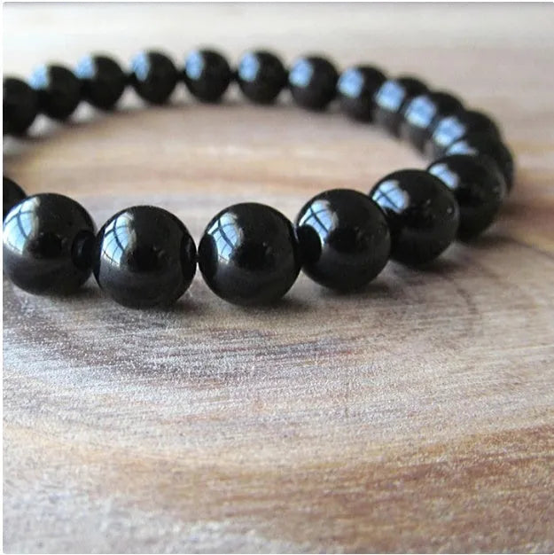 Geometric black onyx bracelet with 8mm beads on a black elastic cord.