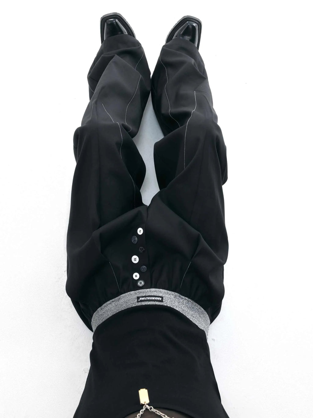Black straight-leg high-waist trousers with button detail on smart casual model
