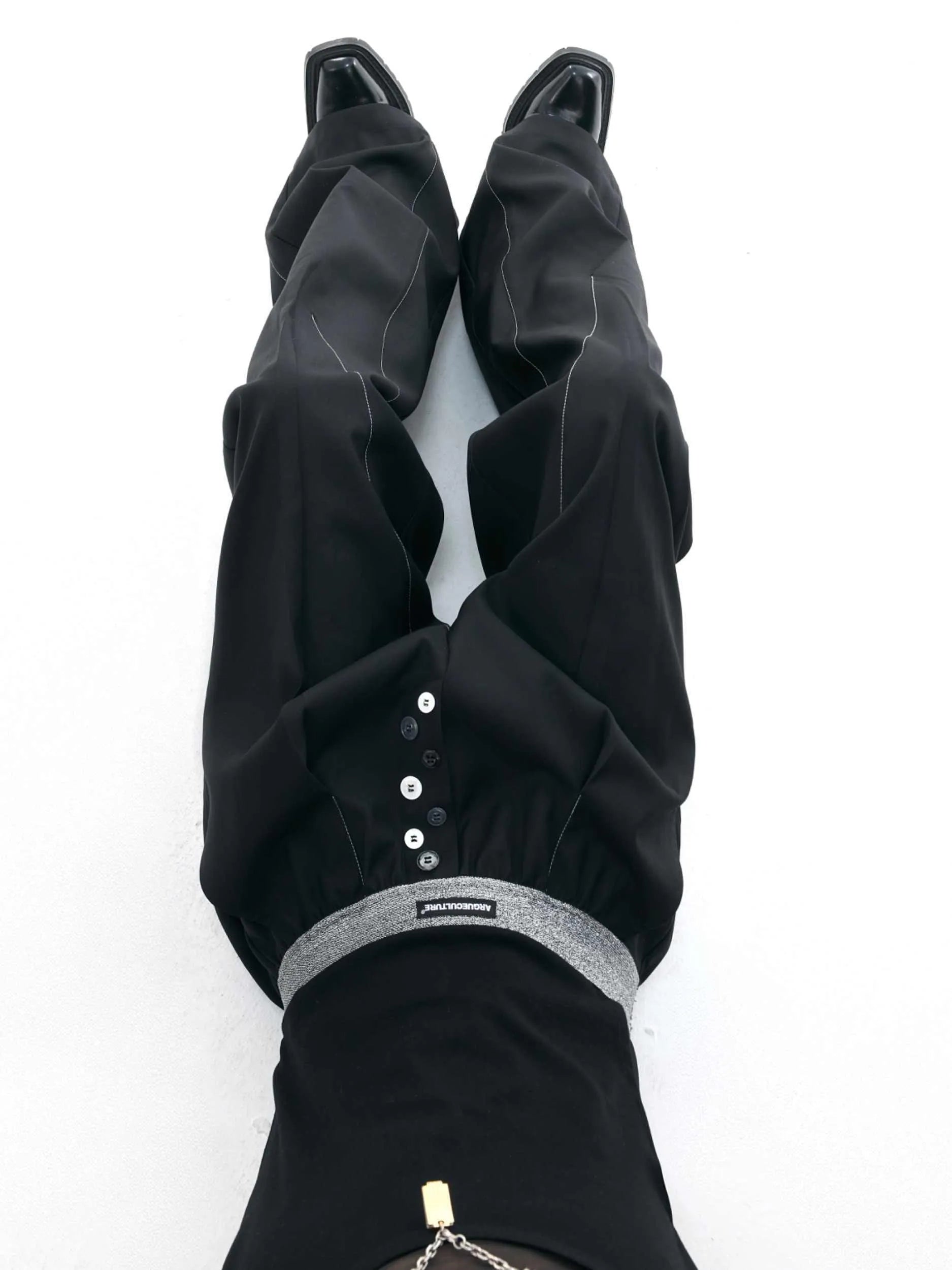 Black straight-leg high-waist trousers with button detail on smart casual model
