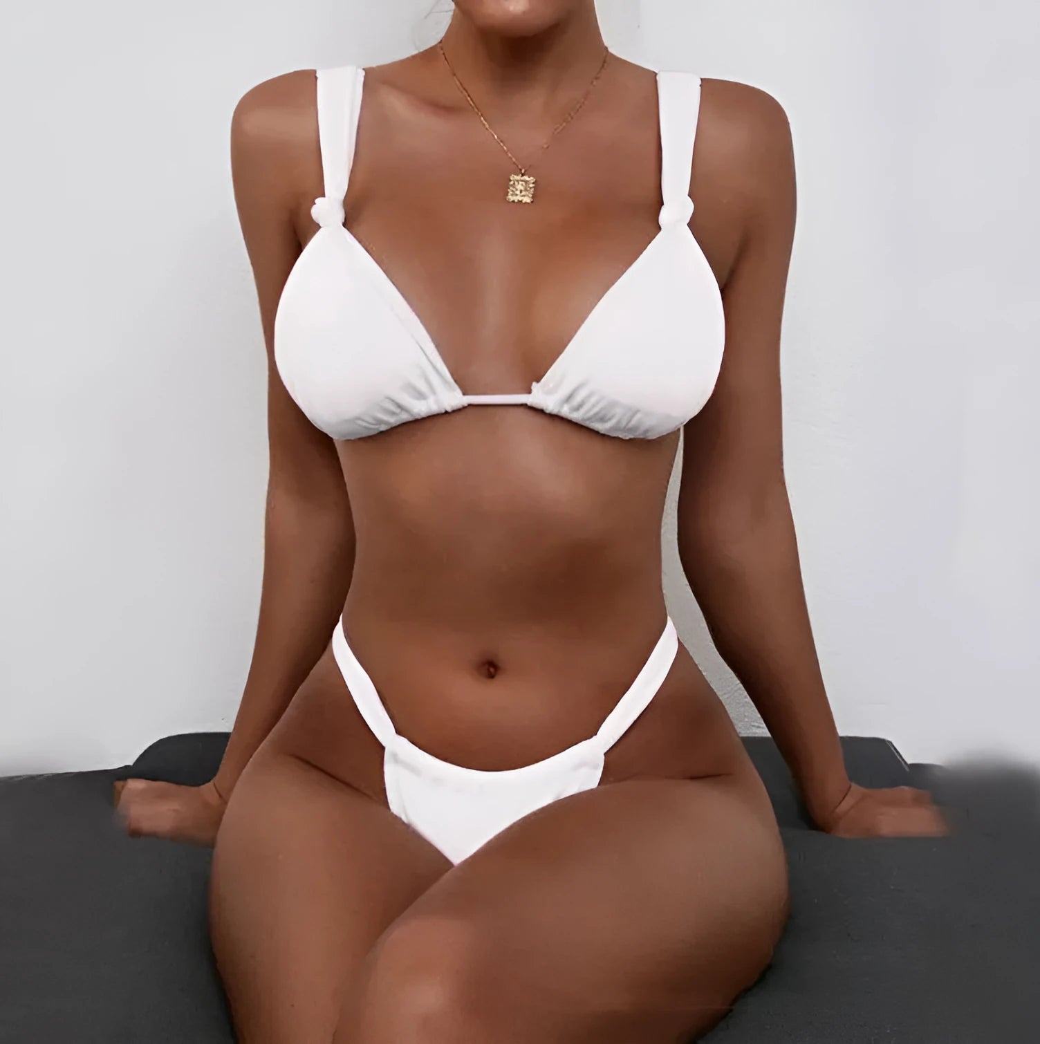Women's pink bikini with knotted pleated straps and a briefs cut, shown on a model.